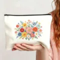 Nahaufnahme der weißen Canvas Kosmetiktasche mit farbiger Blumenstickerei und Reißverschluss. - Stil 3