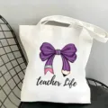 Borsa shopper in tela bianca con design a fiocco di matita viola e stampa vita docente. - Tema Giornata degli Insegnanti Stile 14 / 35x40cm
