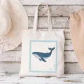 Detailansicht der Segeltuchtasche mit blauem Walmotiv und rustikalem Strandhintergrund. - Blau Wal / 35x40cm