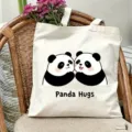 Detailansicht der niedlichen Panda gedruckten Segeltuchtasche auf einem stilvollen Korbstuhl. - Panda Umarmung Stil / 35*40cm