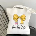 Detail view of white canvas tote bag with cute yellow pencil bow and teacher life text. - Yellow Bowknot Style 1 / 35x40cm