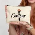 Detailed close-up view of beige canvas makeup bag featuring cute contour print and zipper. - Contour Style (4)