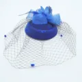 Vue détaillée du chapeau fascinateur bleu roi avec voile en filet pour soirées rétro. - Bleu
