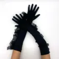 Détail en gros plan de gants longs en satin noir avec volants en tulle et perles. - Noir