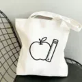 Detailansicht der weißen Canvas Tragetasche mit Apfel und Lineal Grafikdruck für den Alltag. - 35x40cm / Apfel und Lineal Muster