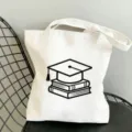 Weisse Leinen Tragetasche mit Diplomkappe Druck, grosse Kapazitaet Schultertasche fuer Studenten. - 35x40cm / Doktorhut und Bücher Muster