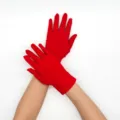 Detail view of short red milk silk stretch gloves, thin breathable design for stage and sun. - Red