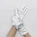 Vue détaillée de gants extensibles en satin blanc, gros plan sur le tissu de soirée. - Blanc cassé