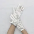 Détail de gants en satin blanc montrant la texture lisse et un design court élégant. - Blanc Cassé