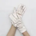 Close-up detail view of the short stretch satin gloves showing smooth fabric texture and fit. - Champagne
