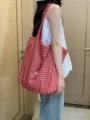 Vista dettagliata della borsa tote in tela a quadri rossi e bianchi, stile borsa a spalla casual. - Rosso