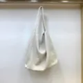 Vista di dettaglio della borsa a spalla in tessuto spigato, morbido stile hobo casual. - Bianco