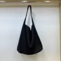 Vista dettagliata della borsa a spalla nera casual e morbida con grande capienza e stile unico. - Nero