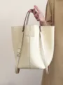 Vista dettagliata della borsa tote minimalista in pelle con cuciture pulite e texture. - Bianco