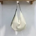 Vista dettagliata della borsa a spalla intrecciata e traforata, con consistenza morbida. - Bianco