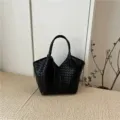 Squisito dettaglio di borsa tote in pelle intrecciata nera con elegante lavorazione artigianale. - Nero