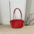 Vista dettagliata della borsa a tracolla in pelle intrecciata rossa, accessorio chic. - Rosso