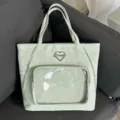 Dettaglio in primo piano della borsa ita verde menta con tasca trasparente e cuore. - Verde