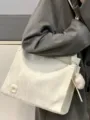Vista dettagliata della grande borsa a tracolla bianca con ciondolo per l'uso quotidiano. - Bianco