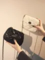 Vista dettagliata della borsa trapuntata con catena, pelle morbida, chiusura a twist e stile chic. - Taglia S / Bianco