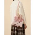 Graziosa borsa a tracolla in peluche rosa con viso sorridente e manico superiore. - Rosa