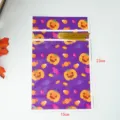 Halloween festive pumpkin and candy pattern plastic gift treat bag with gold ribbon detail view. - 50 Pieces (15x23cm)