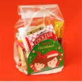Detailansicht der transparenten Weihnachtstüte mit festlicher Dekokarte und diversen Snacks innen. - 50 Stk./Packung / Stil D
