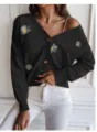 Close-up view of the stylish black cardigan featuring delicate white daisy embroidery and soft fabric. - S / Black