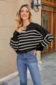Detail view of a stylish black and white striped cropped knit sweater with long sleeves and crew neck. - Black Stripe