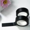 Vista detallada de un rollo de cinta Washi negra lisa con textura limpia para manualidades. - Un rollo de negro