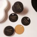Detail shot of round black and kraft thank you paper tags with gold foil text for gift packaging. - Pack of 100 (Diameter 4.3cm) / Black