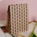 Detail view of a vintage brown kraft paper gift bag with blue triangle leaf pattern design. - Geometric Triangle Tree Pattern / M
