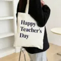Detailed shot of a beige canvas tote bag with teacher's day text print, large capacity. - Style 11