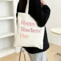 Detail shot of the canvas tote bag with pink Happy Teachers Day print, casual daily scene use. - Style 3