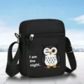 Vue détaillée du sac à bandoulière noir miniature avec motif de hibou et sangle réglable. - Style Hibou