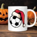 Keramiktasse Detailaufnahme mit festlichem Fussball und Weihnachtsmuetze auf Holztisch. - 350ml Einzelne Tasse / Weiß