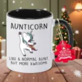 Detailansicht der Keramiktasse mit Einhorn Motiv und rotem Weihnachtsbaumanhänger. - Schwarz Einhorn Stil