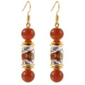 Gold-plated drop earrings featuring charming highland cow floral ceramic beads and red agate. - Bull Head Earrings
