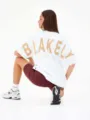 T-shirt bianco oversize a maniche corte con stampa dorata sul retro, stile streetwear. - 7
