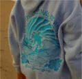 Light blue hooded sweatshirt featuring a detailed wave embroidery and palm tree graphic on back. - XS / Tops / Light Blue Waves