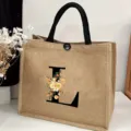 Detailed view of the burlap tote bag featuring a black letter L and floral print design. - Floral Alphabet-L