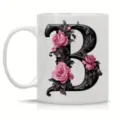 White ceramic coffee mug featuring an ornate black letter B and pink rose design. - Letter B