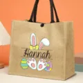 Custom Easter jute tote bag featuring cute bunny ears, paws and colorful eggs design. - Style 2