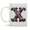 Detailed view of white ceramic coffee mug featuring elegant baroque letter X and rose design. - Letter X