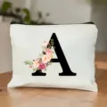 Nahaufnahme des weißen Kosmetiktuchs mit eleganter schwarzem Buchstabe A und Blumenmotiv. - Buchstabe A