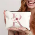 Detailansicht der weißen Canvas Kosmetiktasche mit rosafarbenem Buchstaben R und Blumen. - Buchstabe R