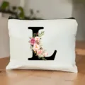 Weißer Kosmetikbeutel mit Reißverschluss und elegantem Blumen-Buchstaben L im Aquarellstil. - L