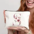Detailansicht des weißen Kosmetiktuchs aus Canvas mit elegantem Buchstaben S und Blumenmuster. - S