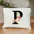 Nahaufnahme der weißen Canvas Kosmetiktasche mit floralem Buchstaben P Druck und Reißverschluss. - Buchstabe P