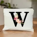 Detailansicht der weißen Kosmetiktasche mit schwarzem Buchstaben W und Aquarellblumen. - Buchstabe W
